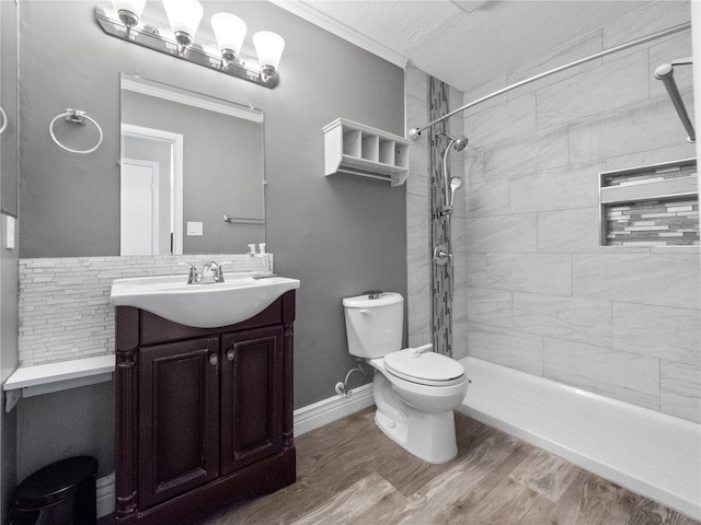 full bathroom featuring toilet, wood finished floors, vanity, and a tile shower