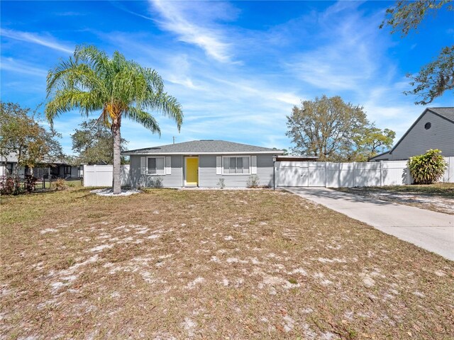 view of front facade featuring concrete driveway and fence