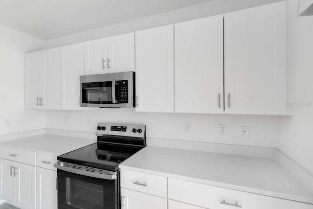 kitchen featuring appliances with stainless steel finishes, white cabinetry, and light countertops