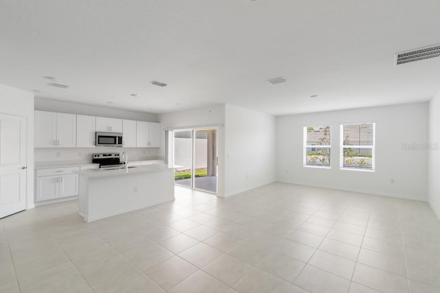 kitchen featuring light countertops, visible vents, light tile patterned flooring, appliances with stainless steel finishes, and open floor plan
