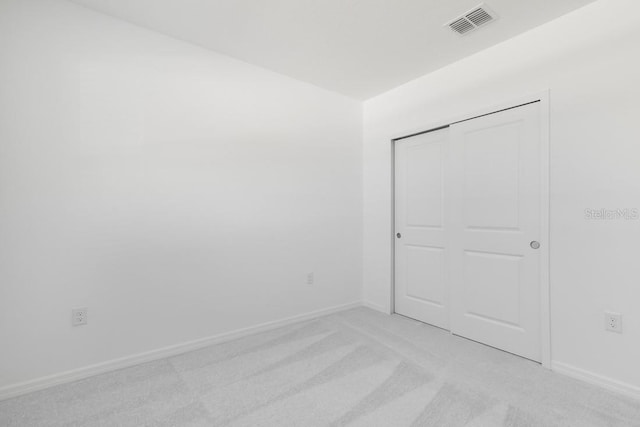 empty room featuring visible vents, baseboards, and light carpet