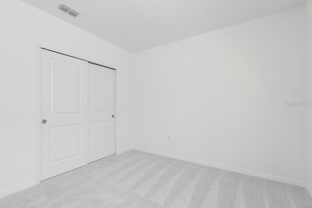 unfurnished bedroom with visible vents, baseboards, and light carpet