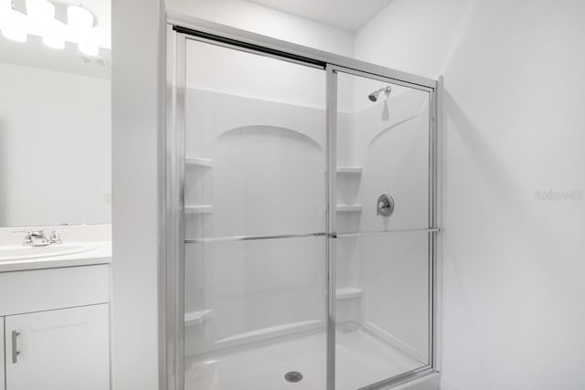 bathroom with a shower stall and vanity