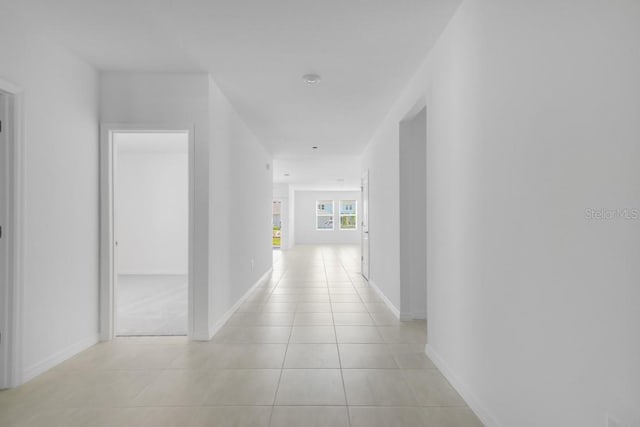 hall with baseboards and light tile patterned floors