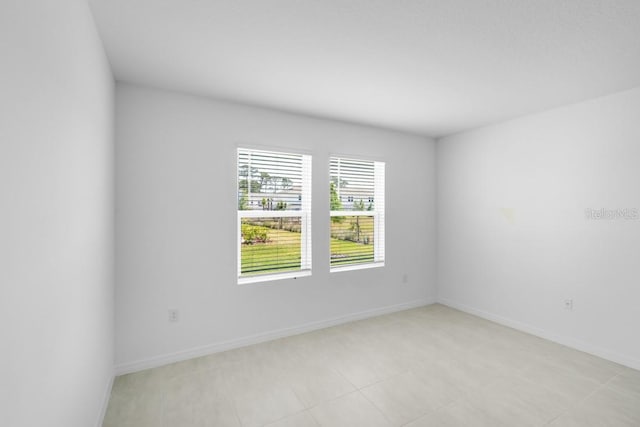 unfurnished room with baseboards and light tile patterned floors