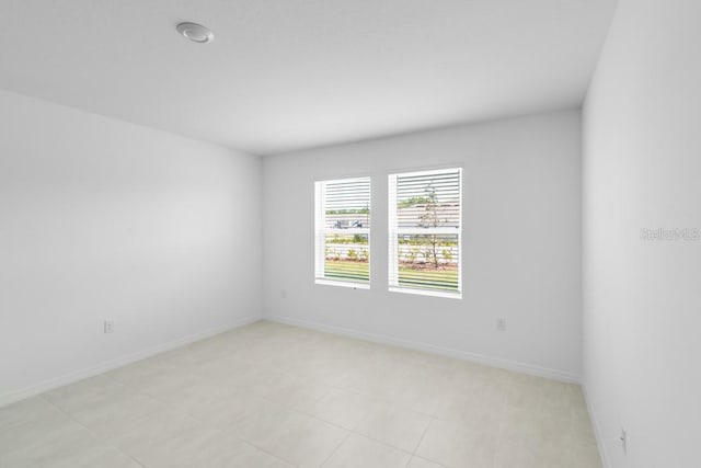 unfurnished room with baseboards and light tile patterned floors