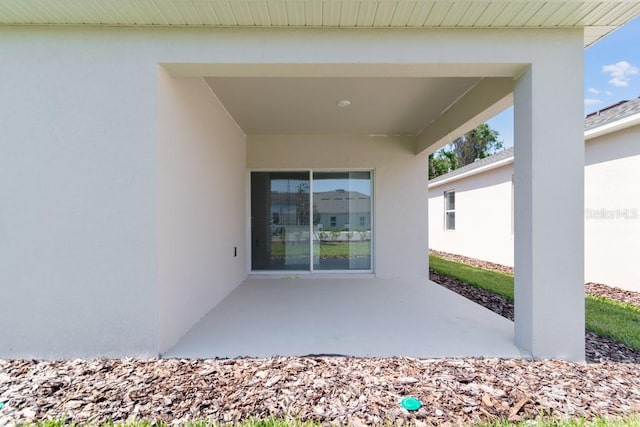 doorway to property with a patio and stucco siding