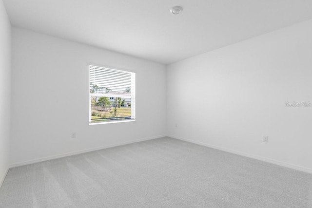 empty room with light carpet and baseboards