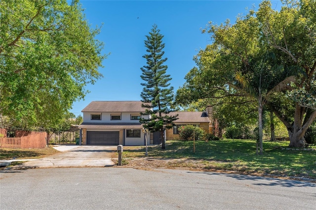 view of front facade with driveway, a front lawn, fence, a garage, and a chimney