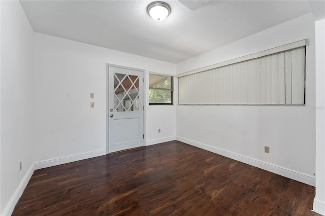 empty room with baseboards and wood finished floors