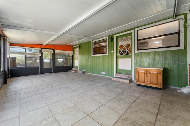 unfurnished sunroom with beamed ceiling