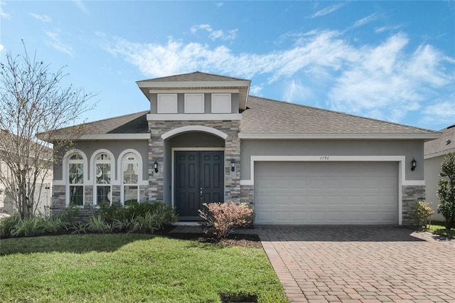 view of front facade with stone siding, stucco siding, decorative driveway, and a front lawn