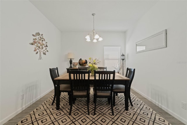 dining room featuring a notable chandelier, baseboards, and dark wood-style flooring