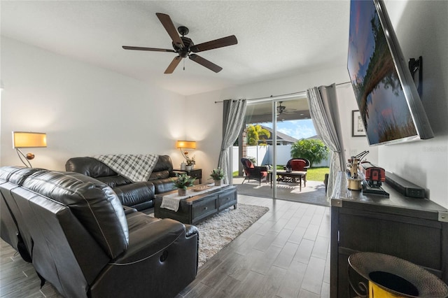 living area with a textured ceiling, ceiling fan, and wood tiled floor