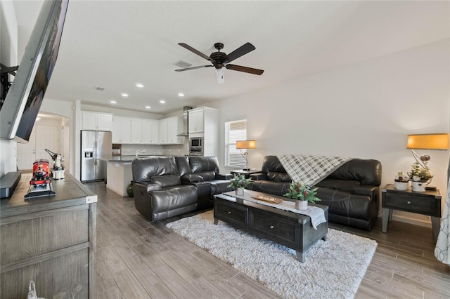 living area featuring recessed lighting, visible vents, light wood-style floors, and a ceiling fan