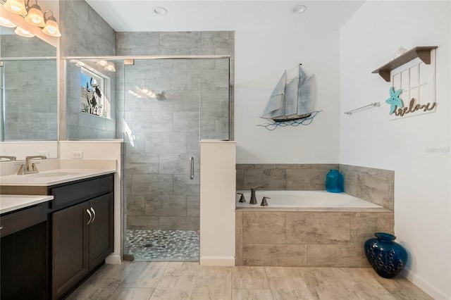 full bath with vanity, a garden tub, and a stall shower