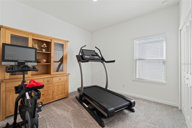 exercise room featuring carpet and baseboards