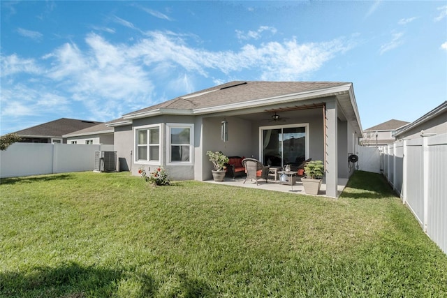 back of property with stucco siding, a yard, ceiling fan, and a patio area