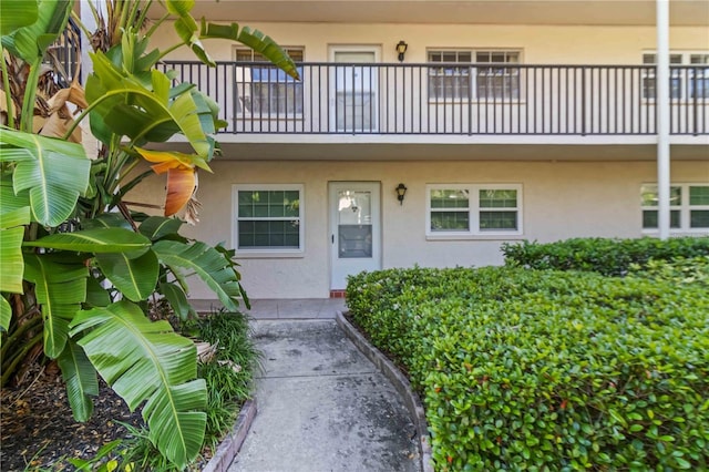 doorway to property with stucco siding and a balcony