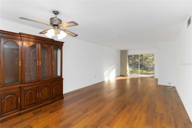 empty room with wood finished floors, visible vents, and ceiling fan