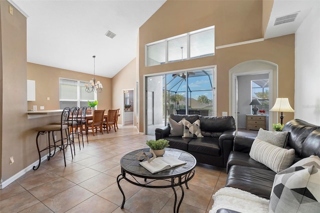 living room with light tile patterned floors, visible vents, high vaulted ceiling, and a chandelier