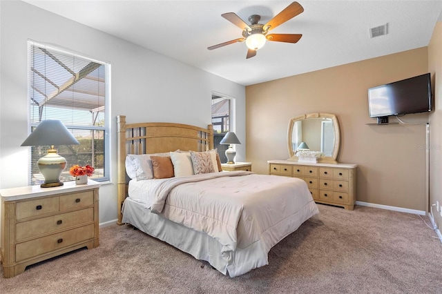 bedroom with visible vents, multiple windows, light colored carpet, and baseboards