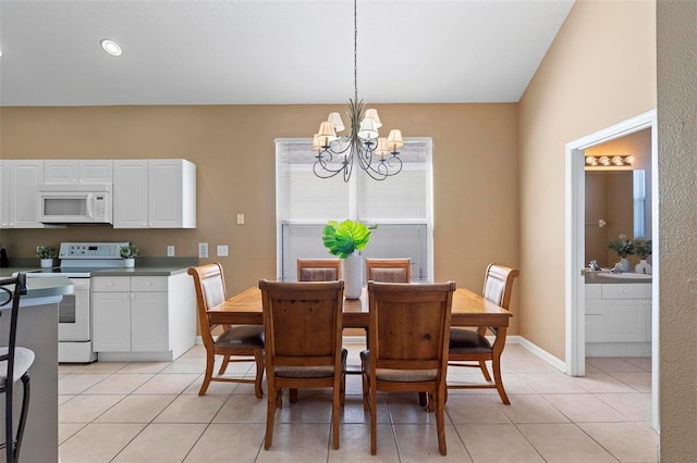 dining space with light tile patterned flooring, baseboards, and a chandelier