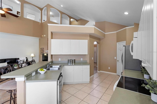 kitchen with a sink, a kitchen breakfast bar, stainless steel appliances, a peninsula, and light tile patterned floors