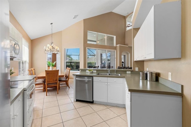 kitchen with a sink, decorative light fixtures, white cabinetry, white appliances, and an inviting chandelier