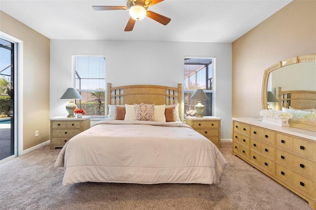 bedroom featuring access to exterior, light colored carpet, baseboards, and ceiling fan