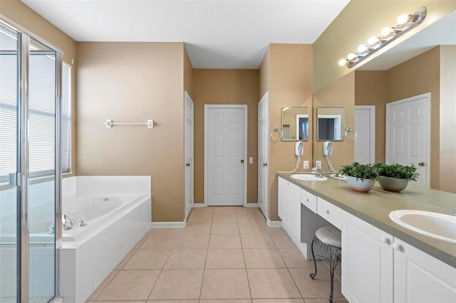 full bathroom featuring a wealth of natural light, tile patterned floors, a garden tub, and a sink