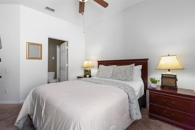 carpeted bedroom featuring baseboards, visible vents, ensuite bath, and ceiling fan