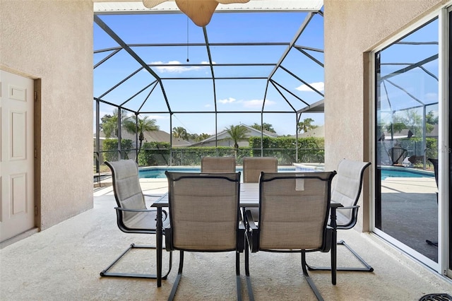 view of patio / terrace with glass enclosure, outdoor dining space, and a fenced in pool