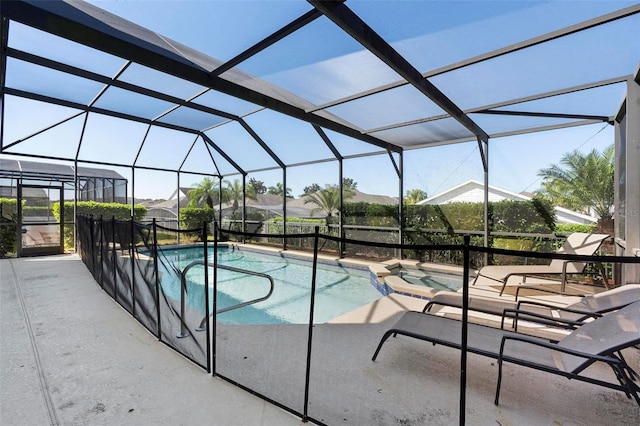 view of pool with glass enclosure, a patio, and a pool with connected hot tub