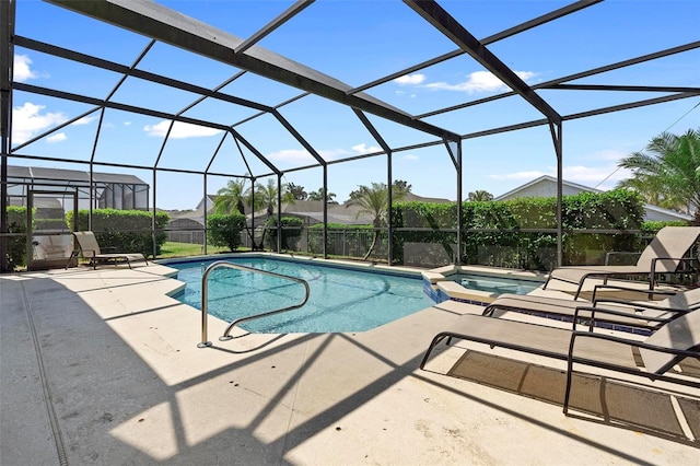 view of pool with glass enclosure, a patio area, and a pool with connected hot tub