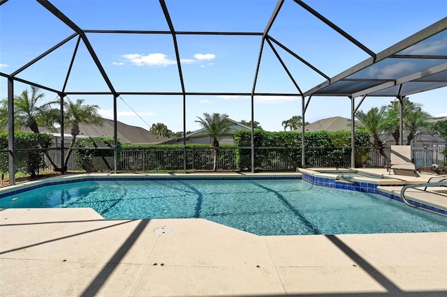 view of swimming pool featuring a lanai, a pool with connected hot tub, and a patio