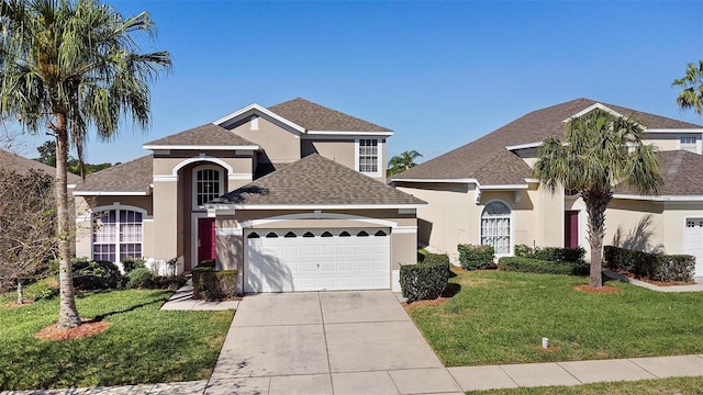 traditional-style house featuring stucco siding, a front yard, concrete driveway, and an attached garage