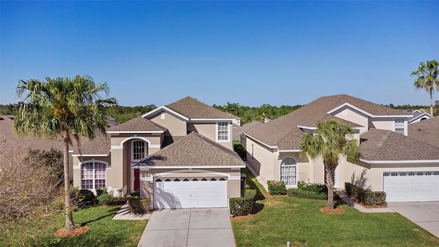 traditional-style house with stucco siding, a front lawn, concrete driveway, and an attached garage