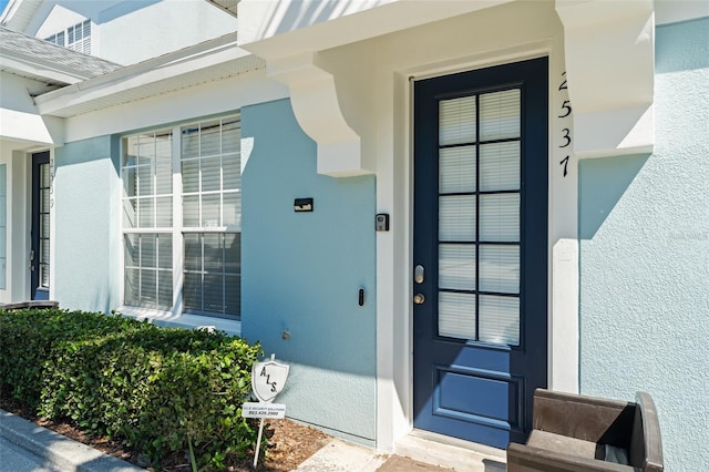 entrance to property featuring stucco siding