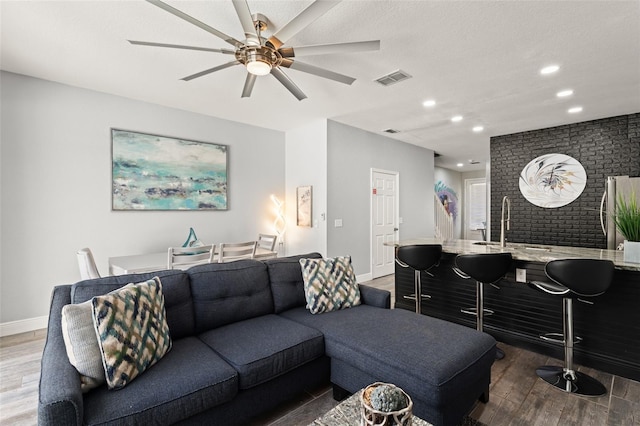 living area with visible vents, wood finished floors, recessed lighting, baseboards, and ceiling fan