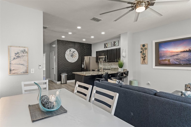 dining area featuring light wood-style flooring, recessed lighting, a ceiling fan, and visible vents