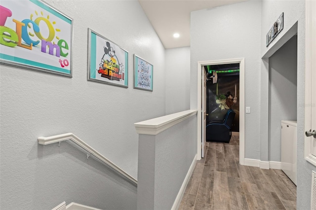 hallway with recessed lighting, baseboards, an upstairs landing, and wood finished floors