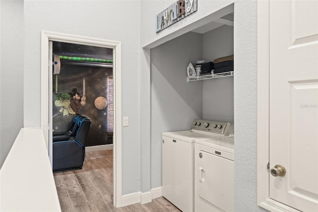 laundry room featuring baseboards, separate washer and dryer, light wood-style flooring, and laundry area