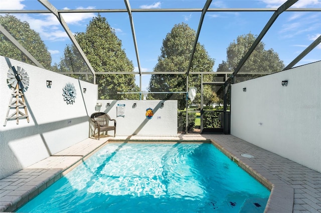 view of swimming pool with glass enclosure, a patio, and a fenced in pool