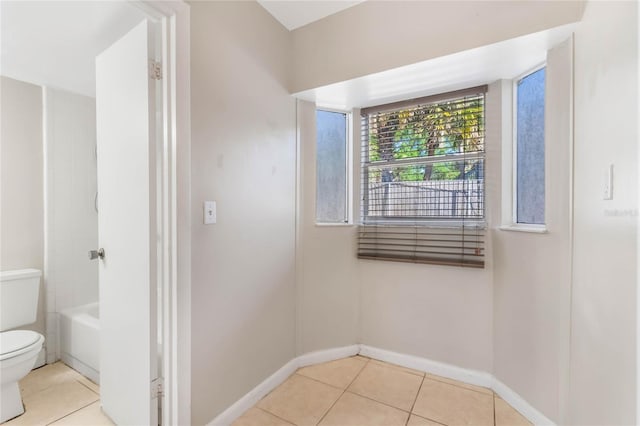 full bath with tile patterned flooring, toilet, and baseboards