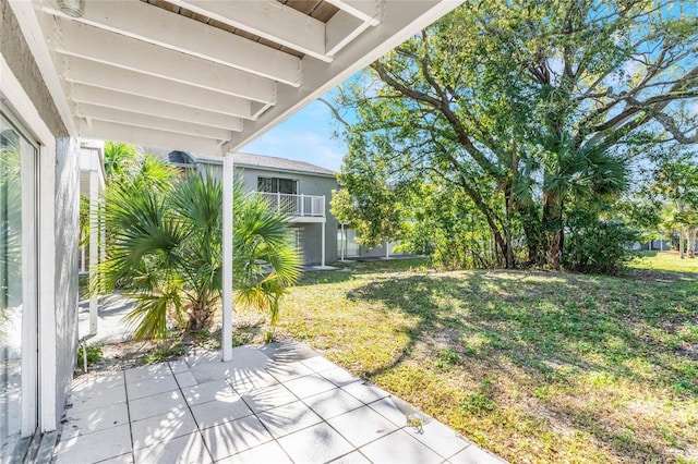 view of yard featuring a patio and a balcony