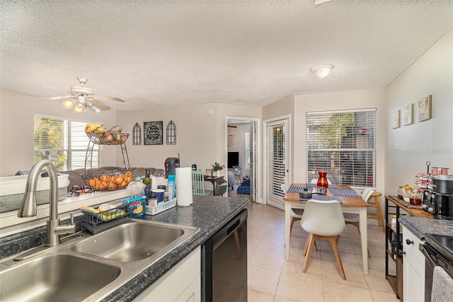 kitchen featuring dark countertops, black dishwasher, stove, and a sink