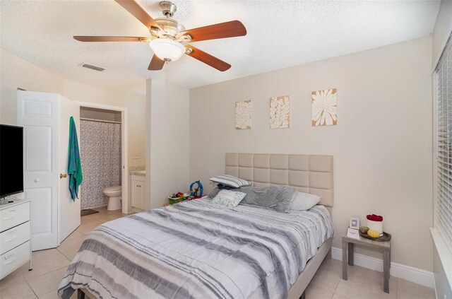 bedroom with light tile patterned floors, baseboards, visible vents, and a textured ceiling