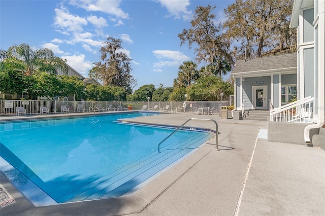 pool with a patio and fence