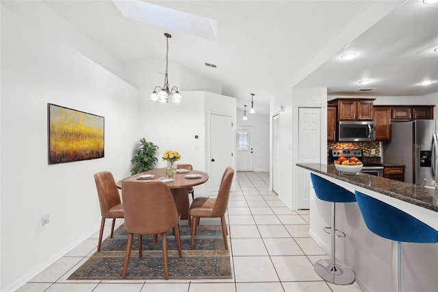 dining room featuring a chandelier, lofted ceiling with skylight, visible vents, and light tile patterned flooring